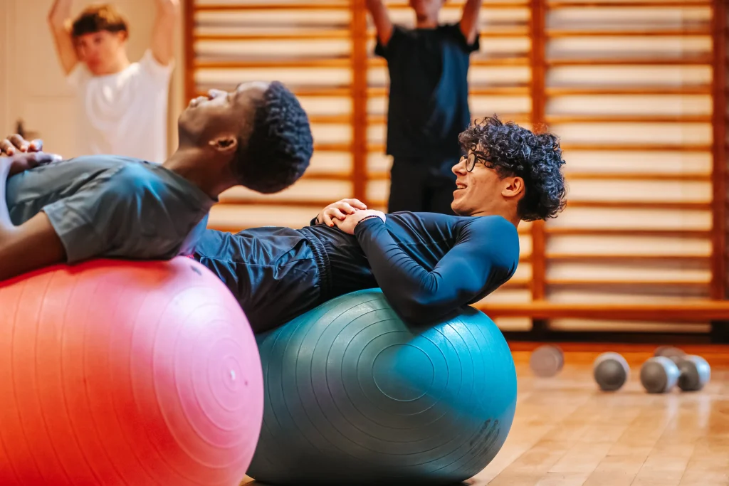 Elève en cours de sport sur ballon de gym